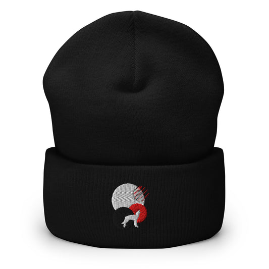 Black cuffed beanie with an embroidered design. There's a white dog looking up with a red, white, and black circle behind it.