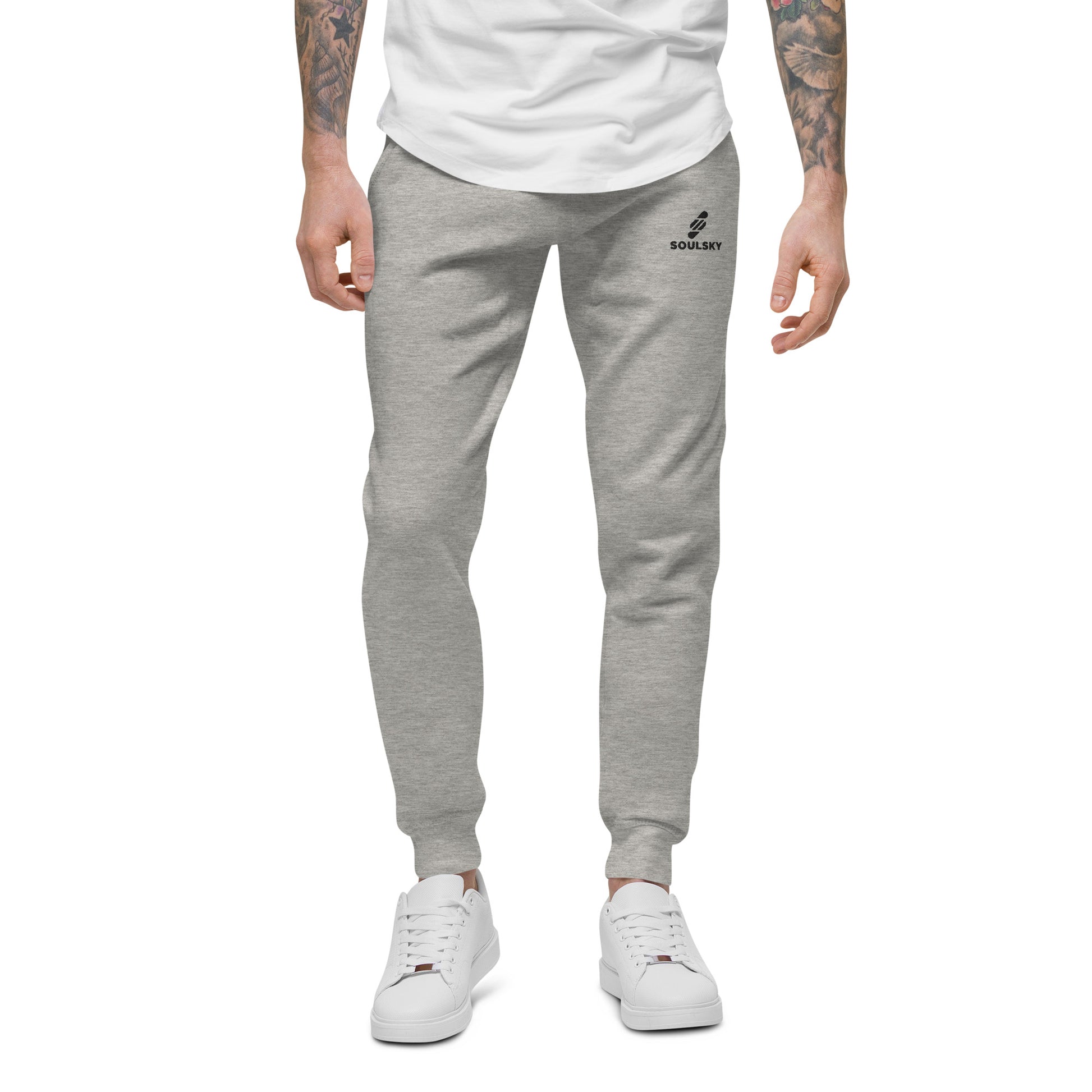 Male model wearing light gray unisex joggers with black embroidered logo on left thigh that says "SOULSKY".